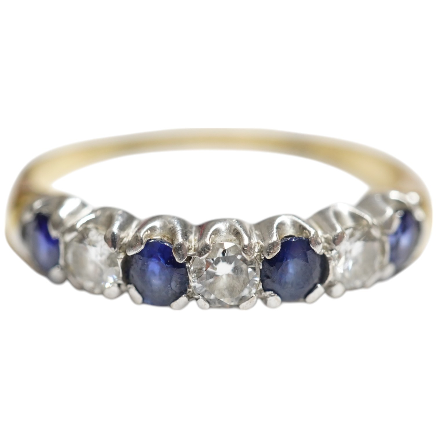 A sapphire and diamond ring, set with an alternating sequence of brilliant-cut diamonds totalling approximately 0.45 carats, and circular-cut sapphires, in 18ct gold, size Z+, British hallmarks, gross weight approximatel